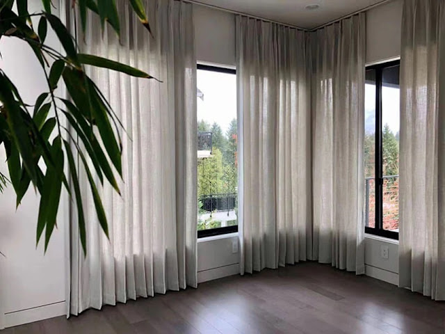 empty room with big windows and nude curtains