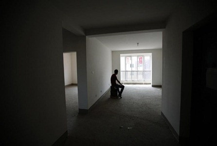 Zhiliang, whose fiancee was onboard Malaysia Airlines Flight MH370, which disappeared in March, is silhouetted at an empty house which he had planned to decorate with her for their marriage, in Tianjin