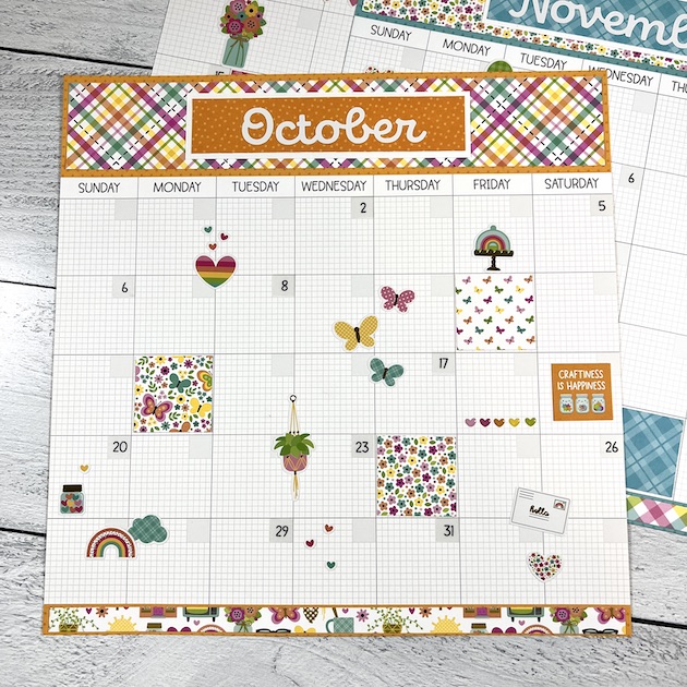12x12 Monthly Calendar Scrapbook Layout with a butterflies, flowers, plaid paper, and lots of other cute stickers