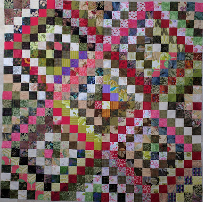 Green Scrappy Trip quilt with pinks and reds on the main diagonal