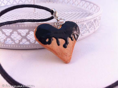 Kawaii cute heart cookie with black syrup on wax cord