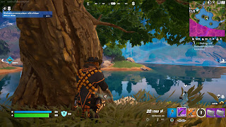 Mancake kneels near a tree in Fortnite.