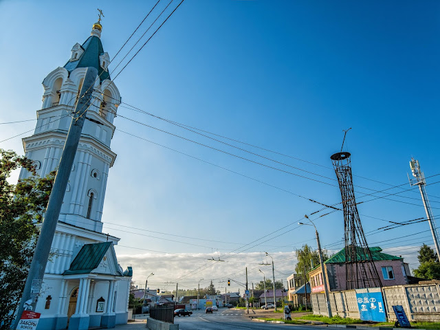 Слева Троицкая церковь, справа Шуховская башня в бывшей пожарной части