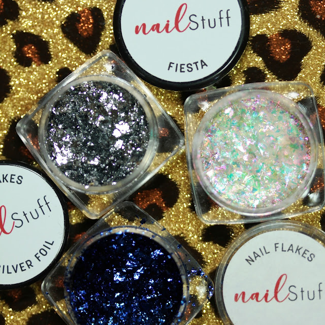 three small jars showing silver, blue and iridescent flakes for nail art