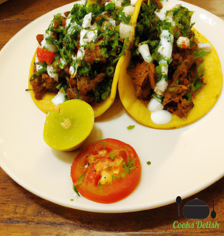 A photo of the finished tacos, arranged on a platter. The tacos are filled with the seasoned beef and topped with lettuce, tomato, cheese, and sour cream. The tacos are garnished with fresh cilantro leaves.