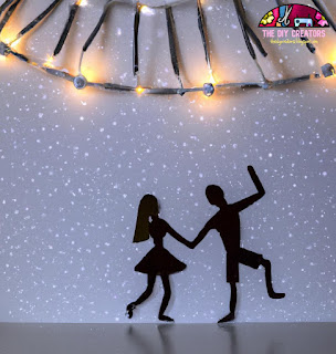 Image of a fairy light backdrop on a white sheet with a couple dancing in front