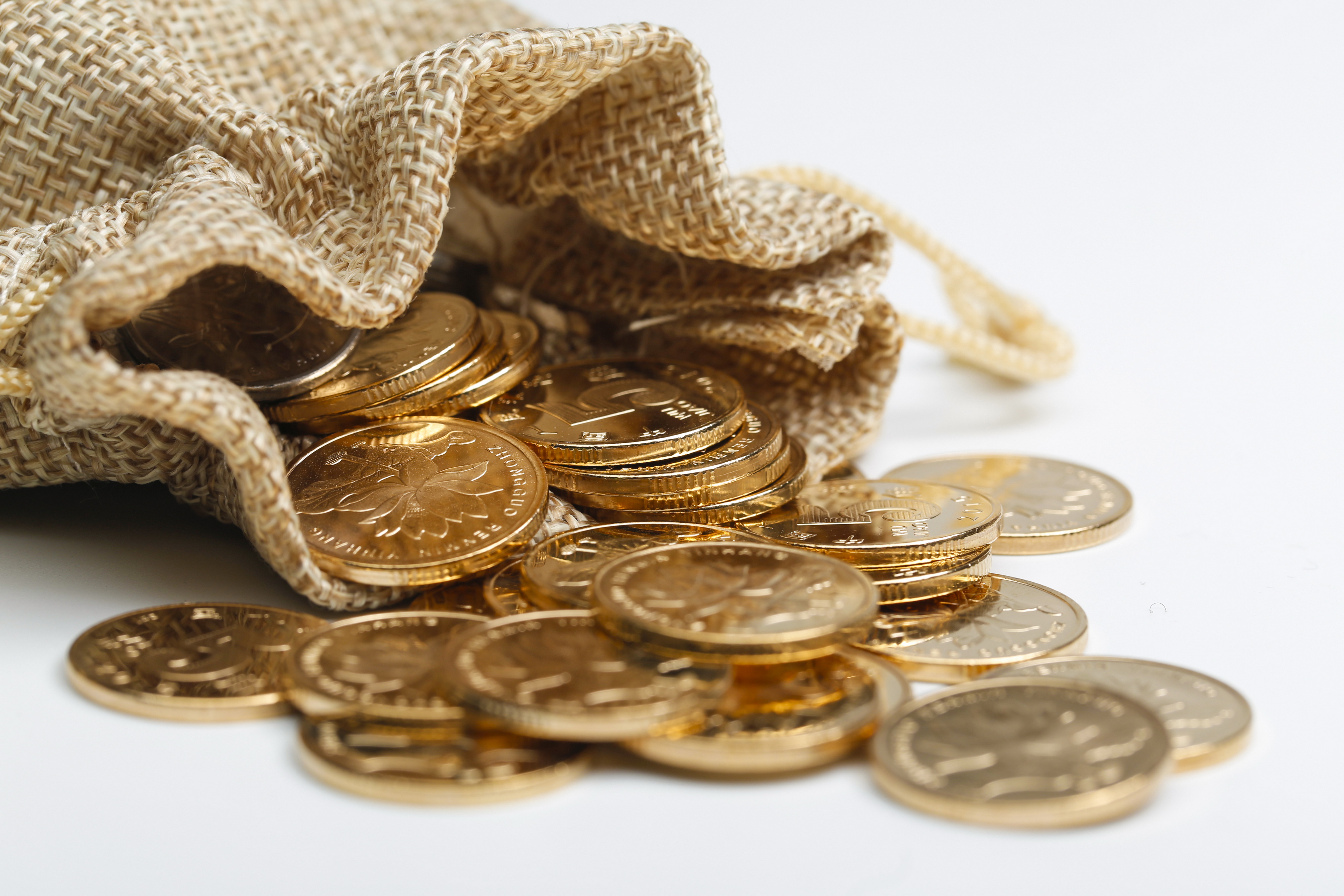 Golden coins get out of cloth bag on white background