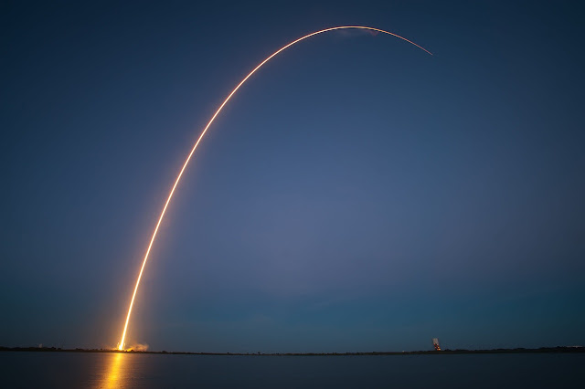 Un razzo lanciato sul mare traccia un arco luminoso nel cielo