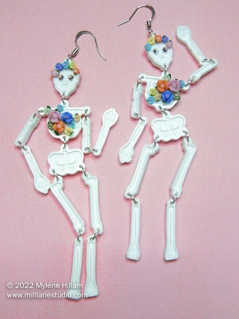White skeleton earrings decorated with miniature clay roses
