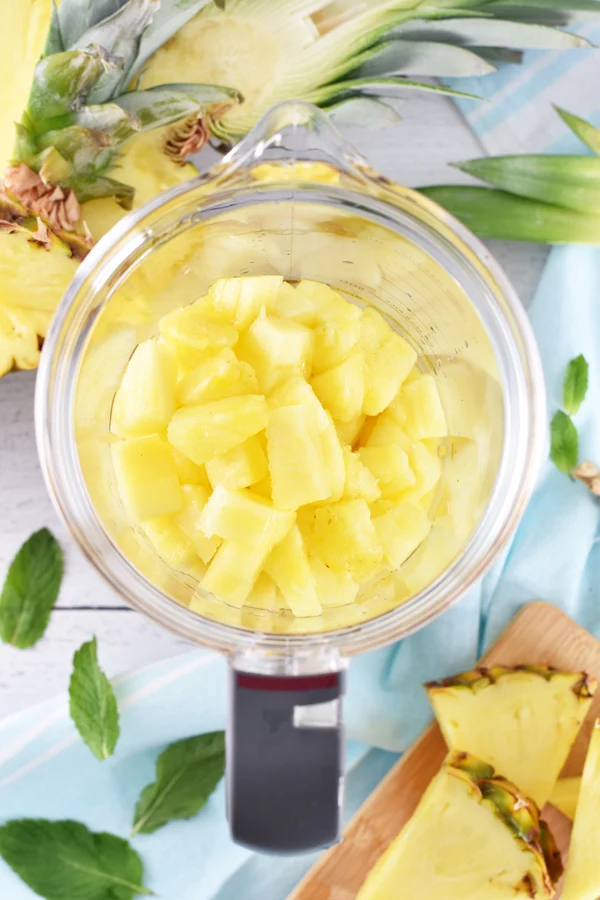 Photo of pineapple chunks in a blender, ready to be used for making pineapple banana smoothies.