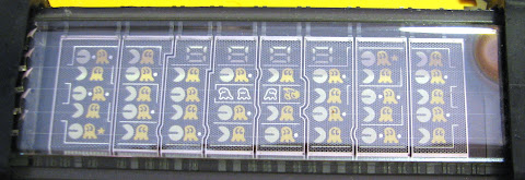 [Image: Close-up photo of the unlit display, revealing that it is a 8x5 grid of small pictures of the game characters and the scene, and a 7-segment, 4-character number display.]