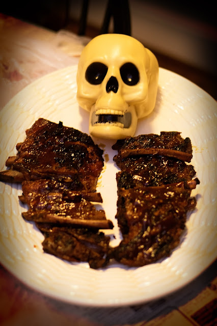 A skull head with BBQ ribs on a platter.