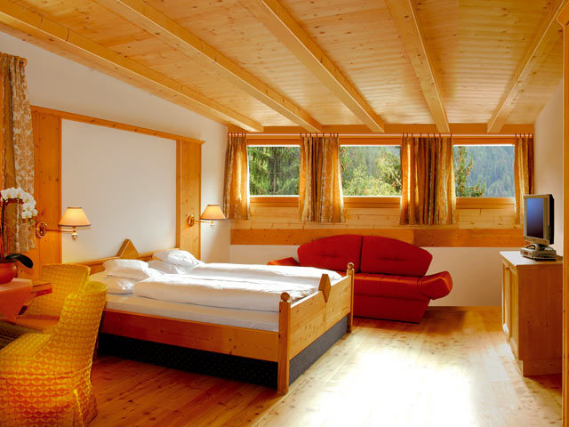 Інтер'єр спальні в дереві з помаранчевим диваном