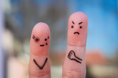 Two fingers with marker showing one happy and one sad