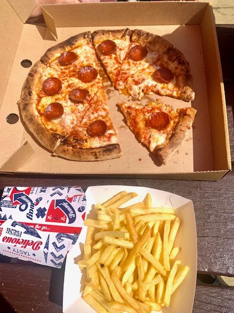 Pepperoni pizza in a box with a side of french fries