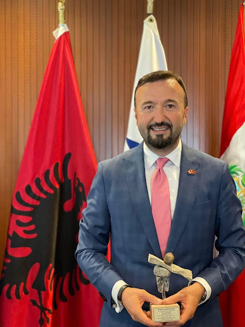 Ermal Muça holding the 'triumph' of the Ambassador of the Year in Canada