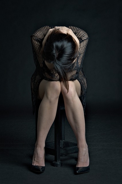 A very beautiful image of a girl sitting on the chair wearing a black-white dress and putting her head down the knees- sad girl dp