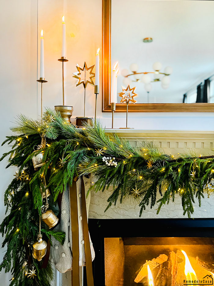 mantel with greenery garland and mirror and candles