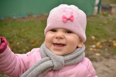 маленькая девочка на улице, в розовой теплой куртке, на свежем воздухе, осень