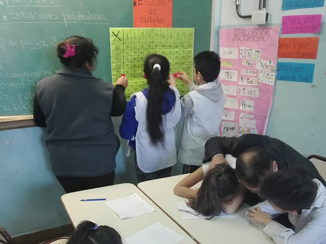 la imagen muestra dos alumnos y una mamá resolviendo la tabla de múltiplos
