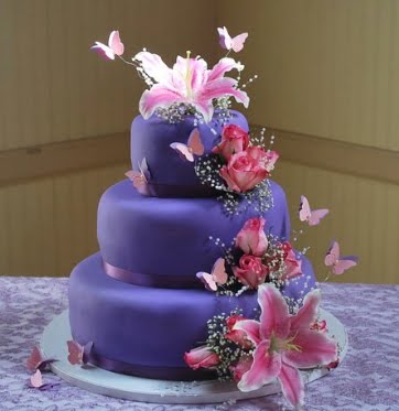 Purple wedding cake over three tiers with heart and white butterflies 