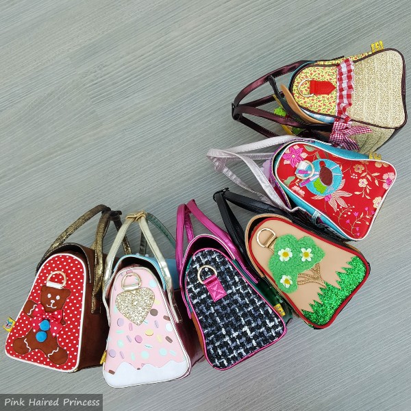 six brightly coloured handbags on their sides flatlay
