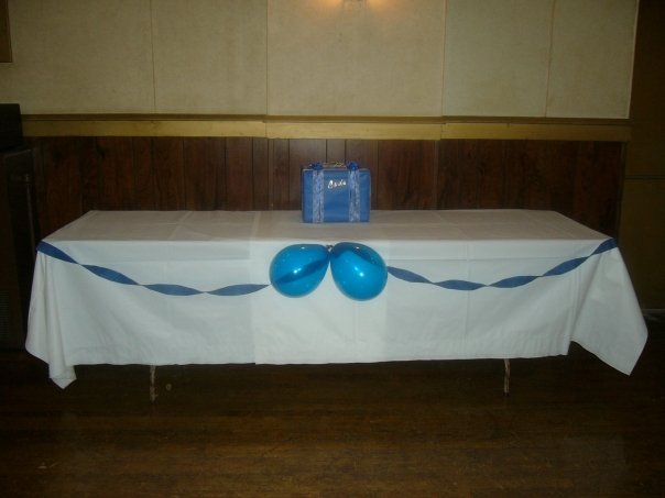 A simple table decorated with blue streamers and blue balloons