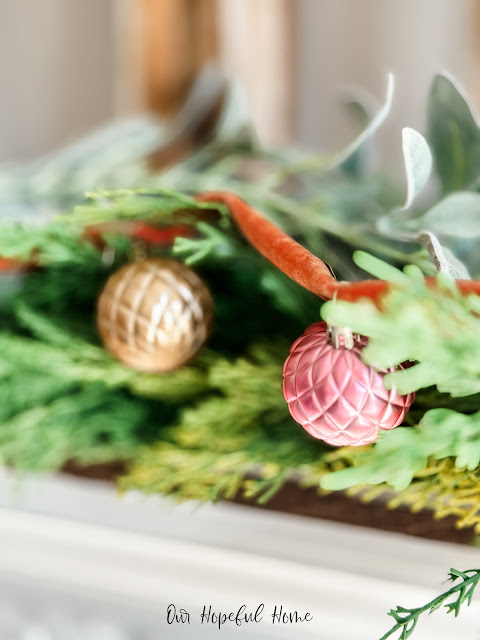 romantic gold and blush Christmas ornaments on mantel garland