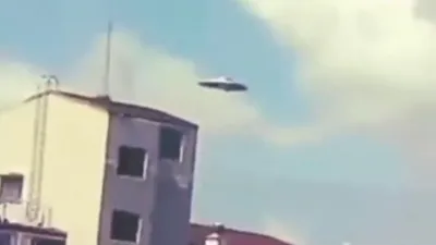 Eye witness films silver Flying Saucer near homes.