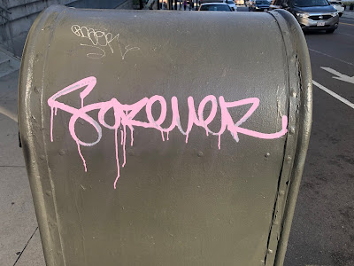 "Forever" spraypainted in purple on mailbox on city street.