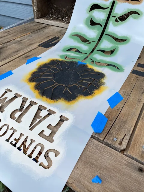 Photo of sunflowers being stenciled on a barn door planter sign.