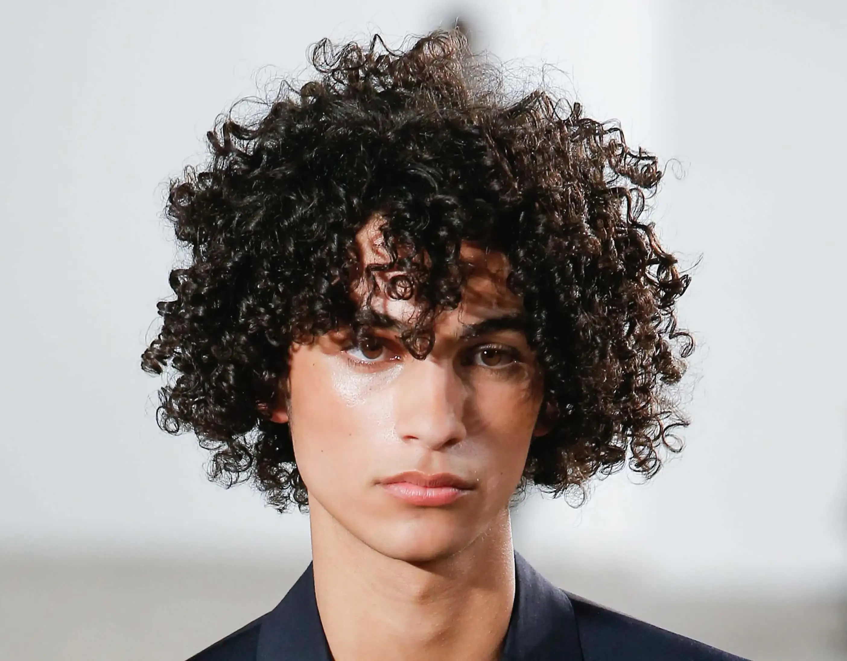 homem jovem com cabelo cacheado preto