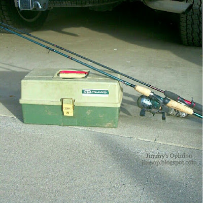 A green plano tackle box with two rod and reels leaning across the top.