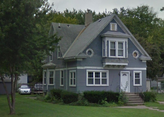 blue grey 1-1/2 story house with enclosed front porch and bay window on the side