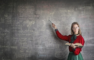 Teacher pointing to influential knowledge on a blackboard