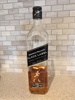 Johnnie Walker Black Label sits in front of a tile backsplash