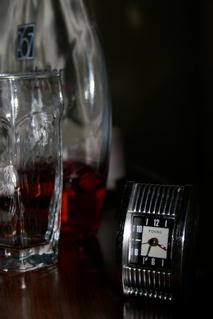 Picture of hotel nightstand with clock at 3:34 in the morning. Empty glass and mostly empty vodka bottle in view.