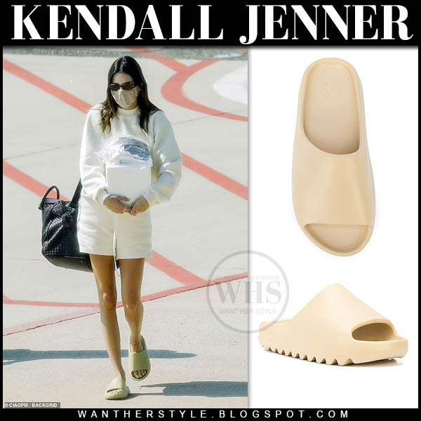 Kendall Jenner in white sweatshirt, white shorts, slides and black bag