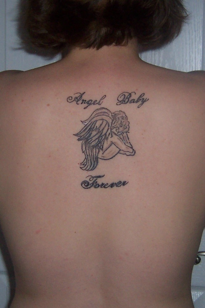 Girl with rosario cross tattoo on her upper back and girl with small cross