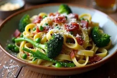 Vibrant Pasta with Broccolini, Peas, and Pancetta in a bowl, with crispy pancetta and Parmesan cheese, served on a rustic table.