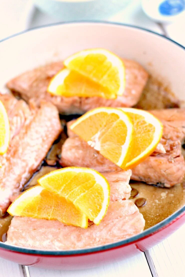 Honey Glazed Salmon in the pan with fresh orange slices