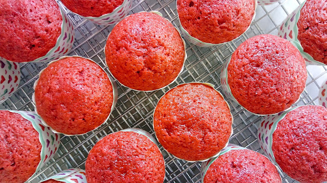 baked red velvet cupcakes sitting on a wire cooling rack