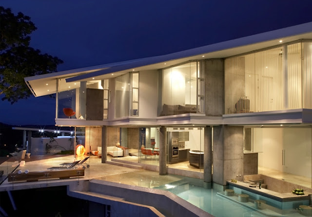 Photo of incredible modern home at night with the swimming pool and terrace