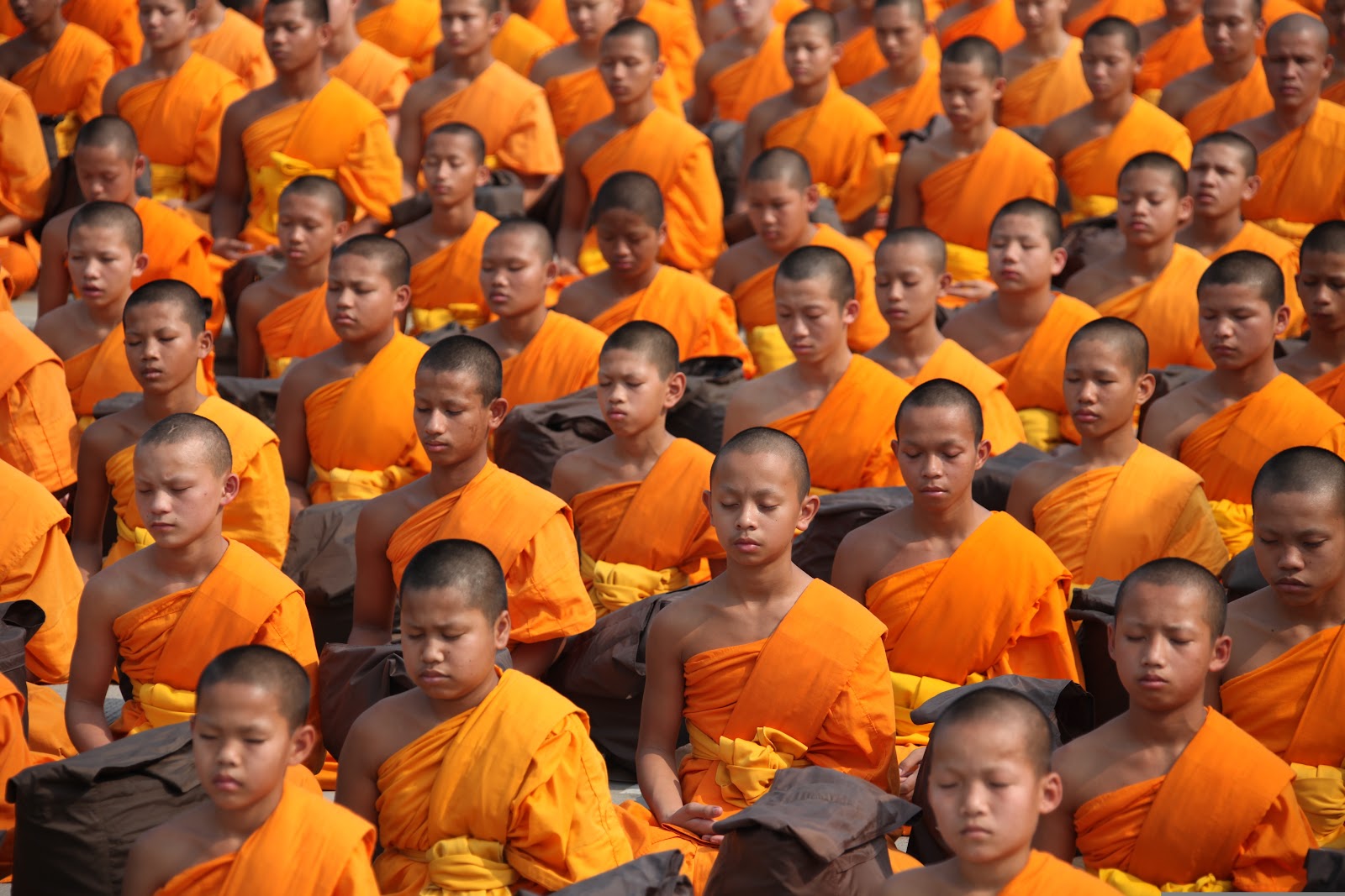 オレンジの僧衣を着て瞑想するタイ人の仏教徒たち