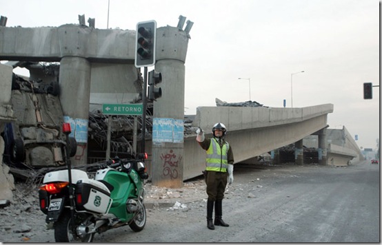 A police officer controls the traffic aside of an elevated highway that collapsed in Santiago following a powerful earthquake in central Chile, Saturday, Feb. 27, 2010.   (AP Photo/David Lillo)