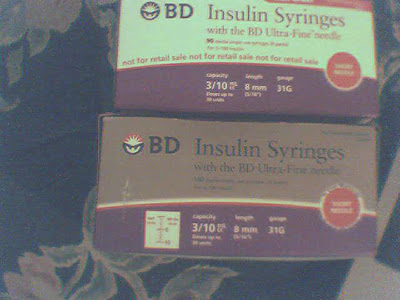 Two boxes advertising BD Insulin Syringes with the BD Ultra-Fine needle- one in white an purple that and one in gray an purple. The gray and purple also shows a display of marks with half units and whole unit measurements