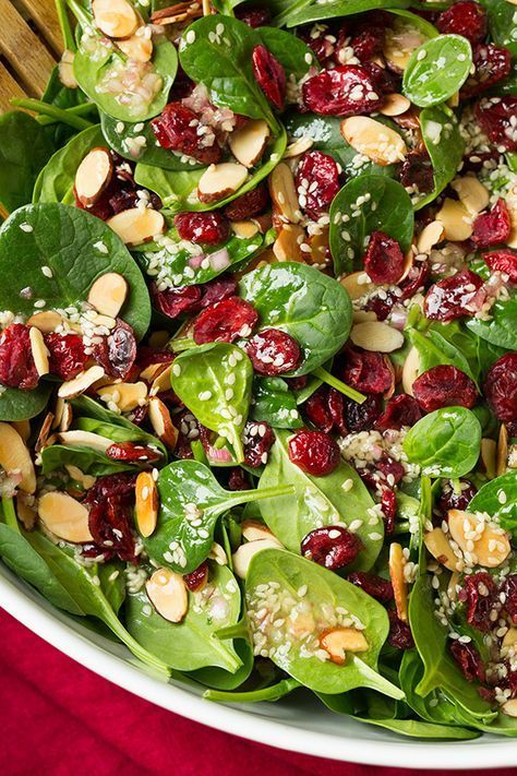 A festive flavorful Spinach Salad! With these pretty red and green colors this is the perfect salad to serve for a Christmas party. It has the perfect blend of sweet, savory, toasted flavor and crunchy goodness. You'll love every last bite of it!