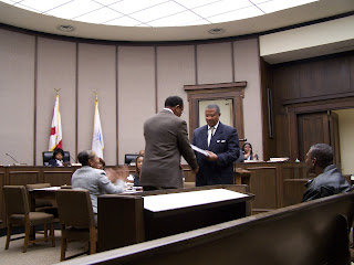 Outgoing Mayor James Perkins accepts a plaque in recognition of service to the city from Council President, and Mayor-elect, George Evans