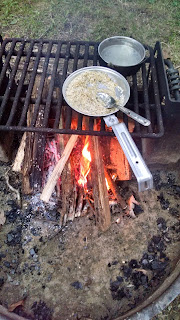 Rice cooking in a mess kit over a campfire