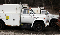 Three White 1988 Chevrolet Utility Trucks